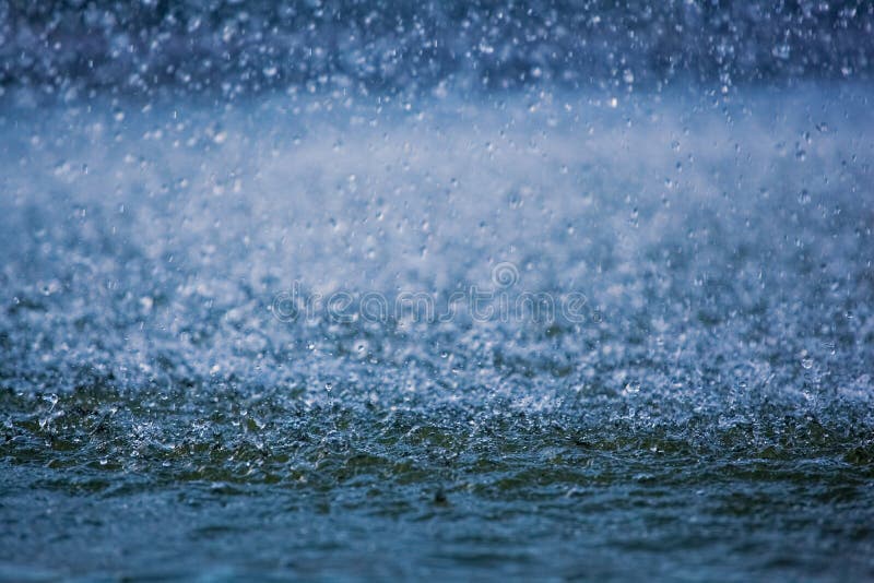 Raindrops running down into a puddle, splashing water visible.