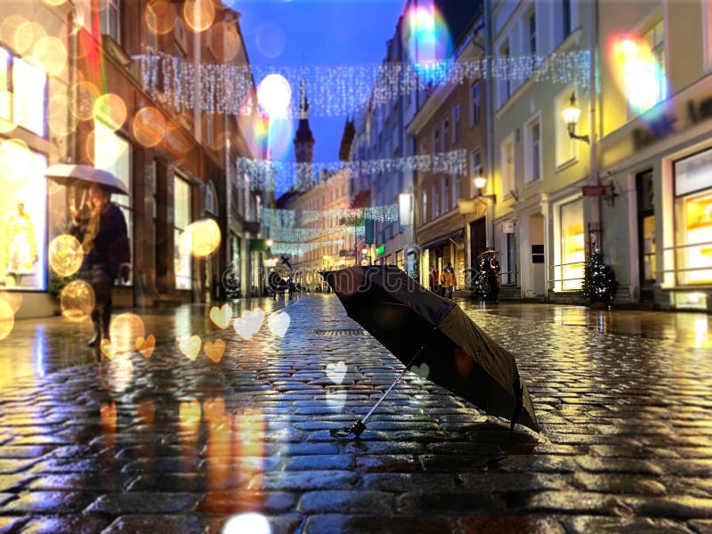 Rainy evening in the city ,people walking with umbrella under rain in Tallinn old town rainy season blur  light ,rainy evening in the city ,people walking with umbrella under rain in Tallinn old town rainy season blur  light winter  Christmas decoration