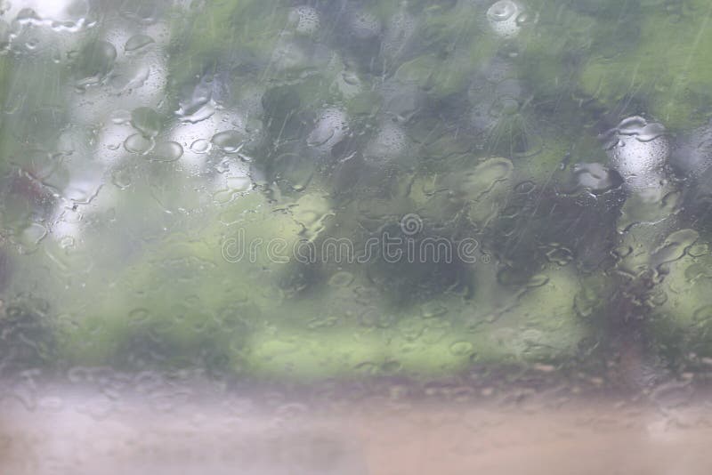 Rainy season, Splash Rain droplets Natural Water Drops on Glass Window in Rainy Season tree background, Rain mist drizzle, Rain