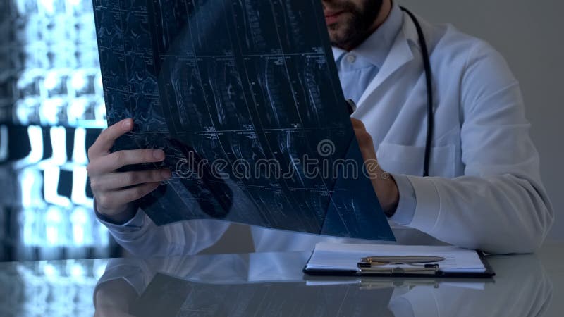 Raio X de exame dos pacientes do especialista de ferimento da medula espinal no escritório, vertebrology imagem de stock Raio X de exame dos pacientes do especialista de ferimento da medula espinal no escritório, vertebrology imagem de stock