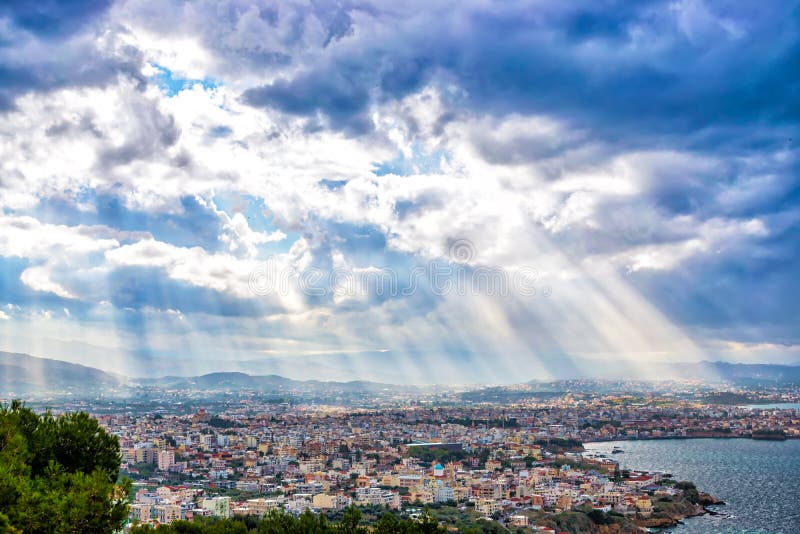 Raios de sol que brilham através das nuvens dramáticas sobre a cidade Chania fotografia de stock Raios de sol que brilham através das nuvens dramáticas sobre a cidade Chania fotografia de stock