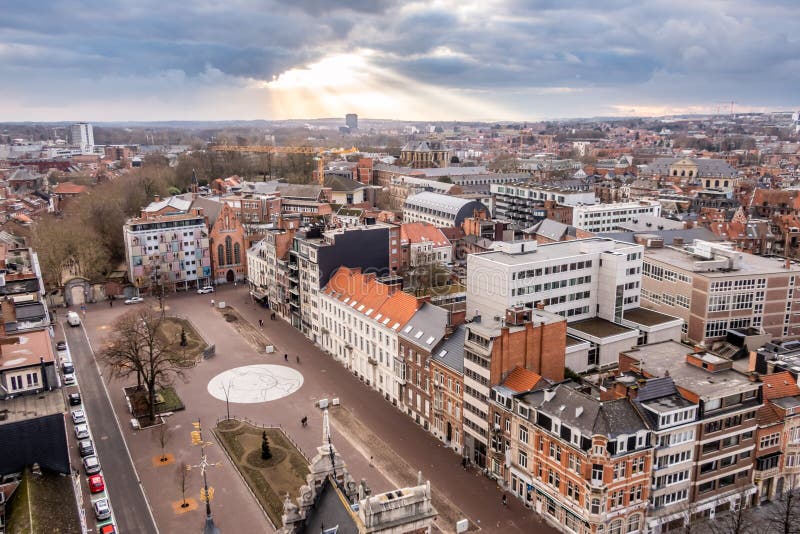 Raios de sol que quebram através da plataforma de nuvem, com um panorama de Lovaina, Flanders, Bélgica foto de stock Raios de sol que quebram através da plataforma de nuvem, com um panorama de Lovaina, Flanders, Bélgica foto de stock