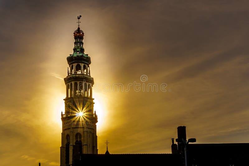 Raios de Sun através do Lange Jan Toren Long John Tower da abadia medieval do ajuste de Sun atrás da torre em MIddelburg fotos de stock royalty free Raios de Sun através do Lange Jan Toren Long John Tower da abadia medieval do ajuste de Sun atrás da torre em MIddelburg fotos de stock royalty free