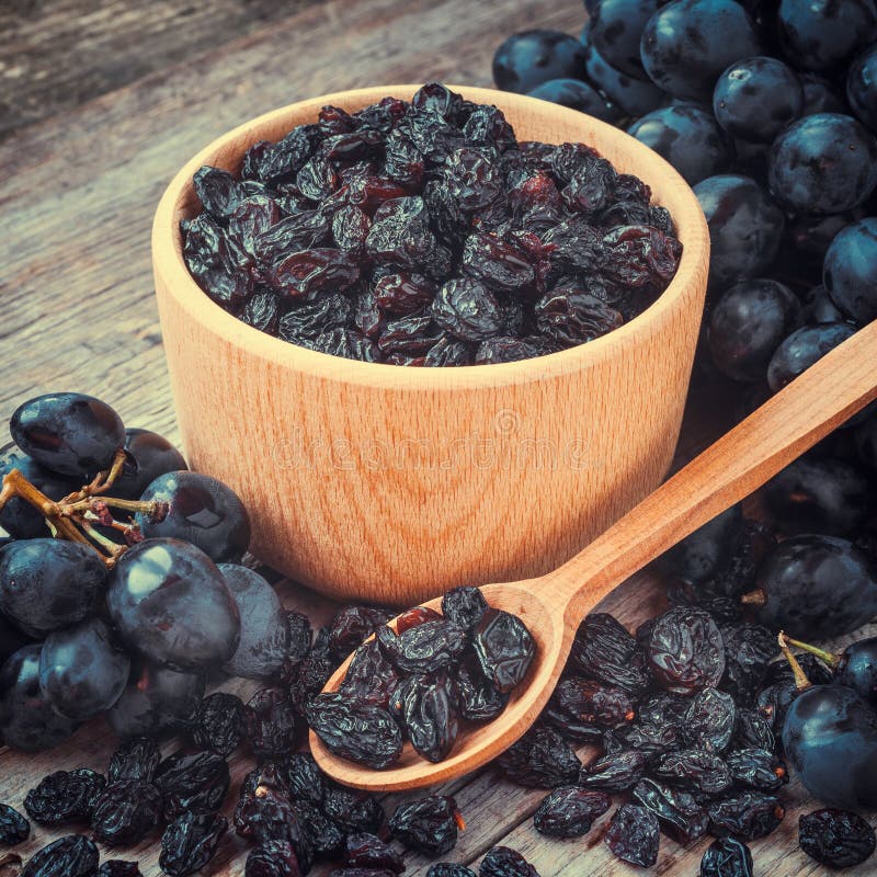 Raisins in Bowl and Blue Grapes on Table Stock Photo Image of board