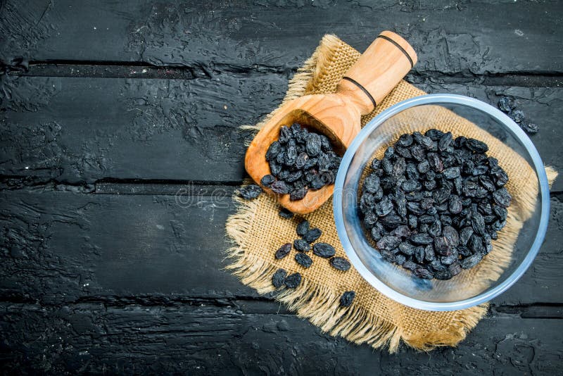Raisins in a bowl with a scoop stock photo