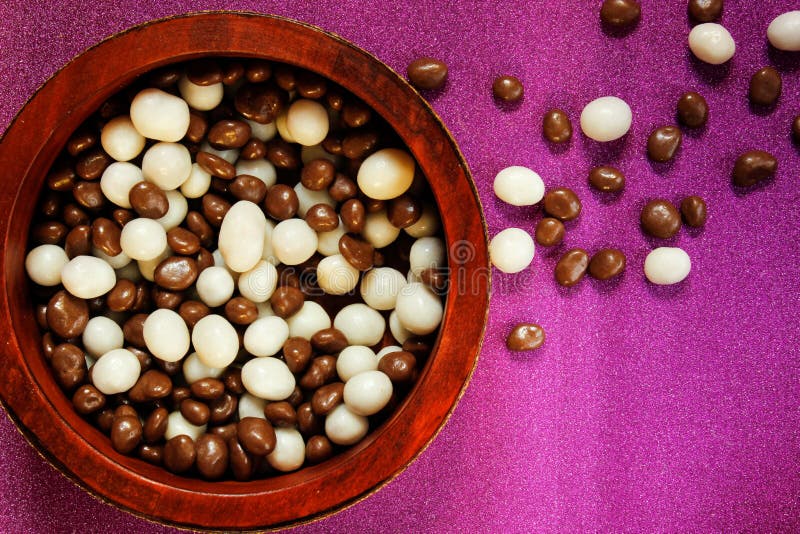 Raisins in sweet white and brown glaze in a basket on a pink surface. Raisins in a sweet white and brown glaze in a basket on a pink surface. View from above stock photo Raisins in sweet white and brown glaze in a basket on a pink surface. Raisins in a sweet white and brown glaze in a basket on a pink surface. View from above stock photo