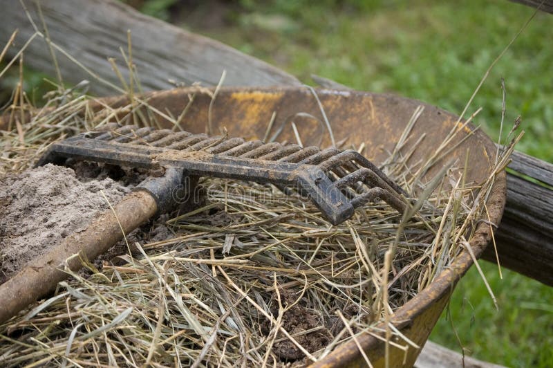 Rake on wheelbarrow royalty free stock photos