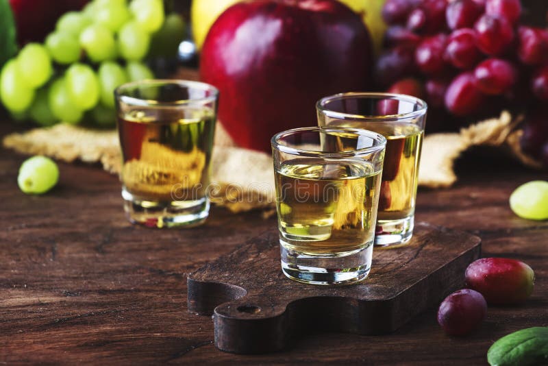 Rakia, raki o rakia - forte tipo basato sui frutti fermentati, tavola di legno d'annata, natura morta del brandy della bevanda al fotografia stock libera da diritti Rakia, raki o rakia - forte tipo basato sui frutti fermentati, tavola di legno d'annata, natura morta del brandy della bevanda al fotografia stock libera da diritti