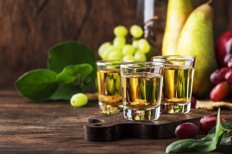 Rakija, raki of rakia - Balkan sterke alcoholisch drinkt brandewijntype dat op vergiste vruchten, uitstekende houten lijst, still royalty-vrije stock afbeelding Rakija, raki of rakia - Balkan sterke alcoholisch drinkt brandewijntype dat op vergiste vruchten, uitstekende houten lijst, still royalty-vrije stock afbeelding