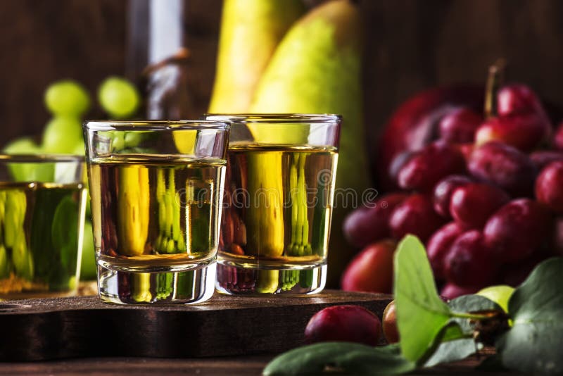 Rakija, raki or rakia - Balkan strong alcoholic drink brandy type based on fermented fruits, vintage wooden table, still life in