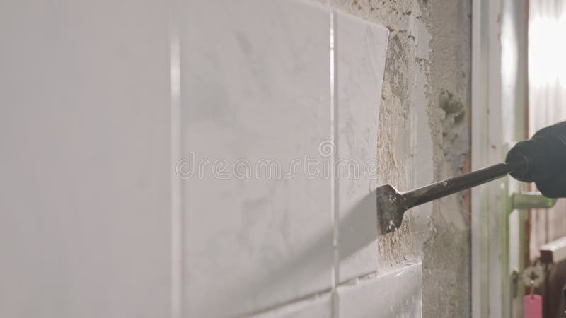 Ralenti d'un marteau rotatif brisant des carreaux en céramique plus d'un mur clips vidéos