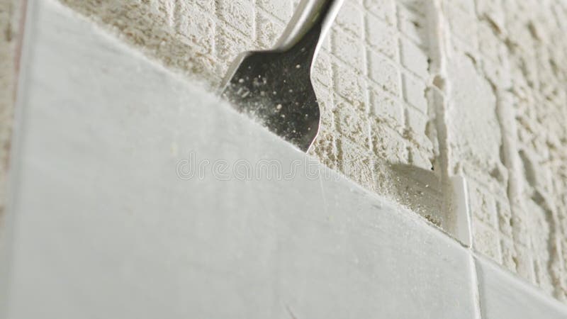 Ralenti d'un marteau rotatif brisant des carreaux en céramique plus d'un mur banque de vidéos