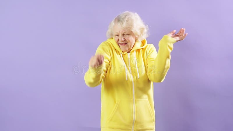 Rallenta il movimento e una donna anziana ascolta musica e danza in studio