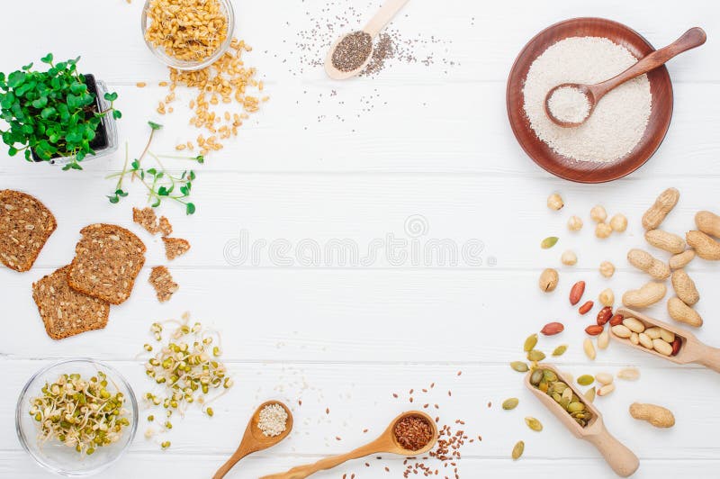 Ram av frö, rädisagroddar, bönor, muttrar och knäckebröd, havrekli på vit träbakgrund royaltyfri fotografi Ram av frö, rädisagroddar, bönor, muttrar och knäckebröd, havrekli på vit träbakgrund royaltyfri fotografi