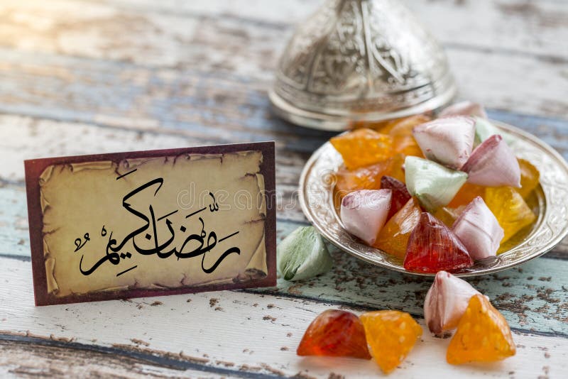 Ramadankerimtext i arabiska på tappningtabellen med godisar arkivfoton Ramadankerimtext i arabiska på tappningtabellen med godisar arkivfoton