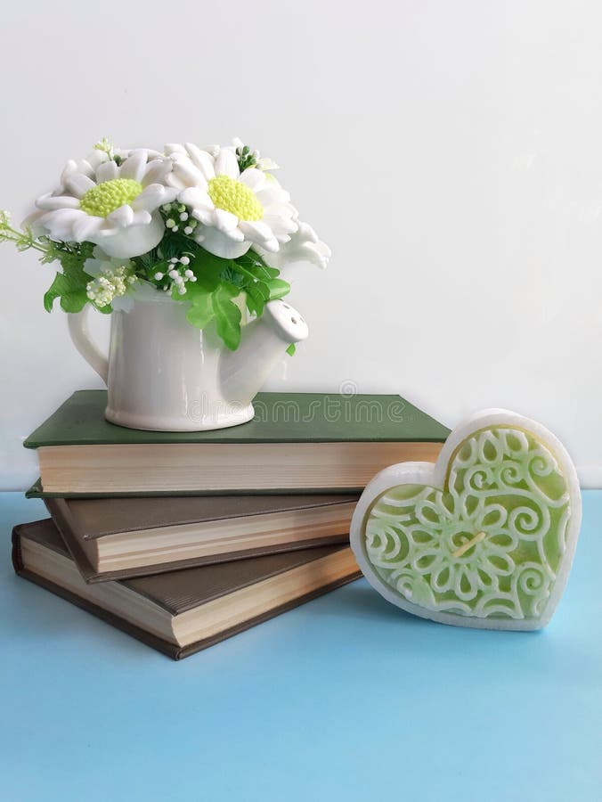 Ramalhete das flores em livros velhos, coração decorativo na mesa azul no fundo branco imagens de stock royalty free Ramalhete das flores em livros velhos, coração decorativo na mesa azul no fundo branco imagens de stock royalty free