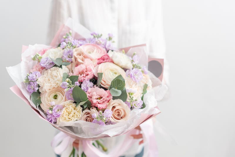 Ramo cortado fresco hermoso de flores mezcladas en mano de la mujer el trabajo del florista en una floristería Pastel delicado imagen de archivo libre de regalías
