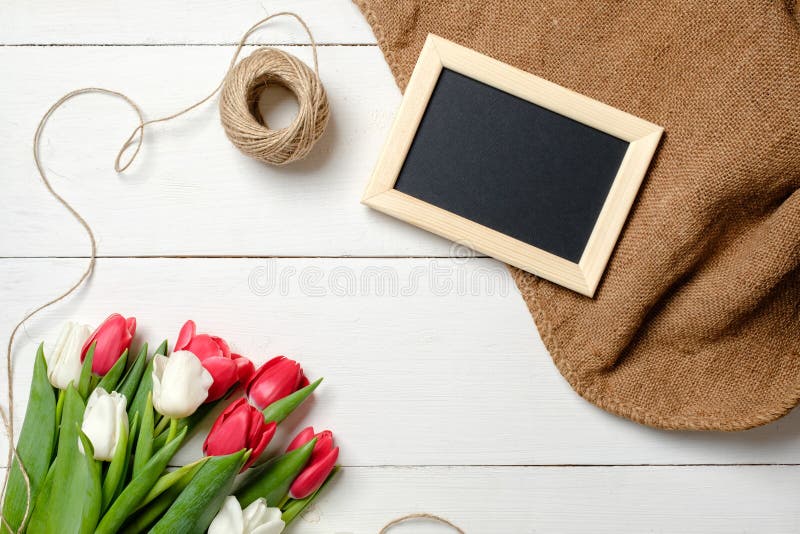 Ramo de flores de los tulipanes, marco en blanco, guita, arpillera en la tabla de madera blanca Tarjeta de felicitación del vinta imagen de archivo libre de regalías Ramo de flores de los tulipanes, marco en blanco, guita, arpillera en la tabla de madera blanca Tarjeta de felicitación del vinta imagen de archivo libre de regalías