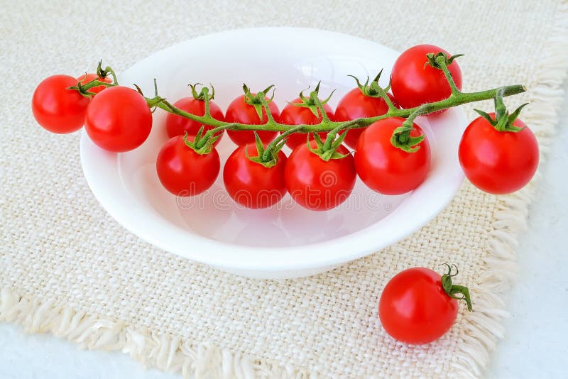 Ramo dei pomodori ciliegia rossi maturi su una ciotola bianca sopra il tovagliolo di tavola guarnito Verdure, vegetariano e cibo fotografie stock libere da diritti Ramo dei pomodori ciliegia rossi maturi su una ciotola bianca sopra il tovagliolo di tavola guarnito Verdure, vegetariano e cibo fotografie stock libere da diritti