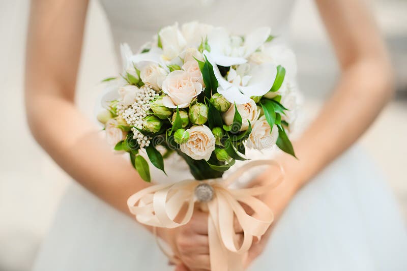 Ramo en las manos de la novia de rosas del arbusto imagen de archivo libre de regalías Ramo en las manos de la novia de rosas del arbusto imagen de archivo libre de regalías