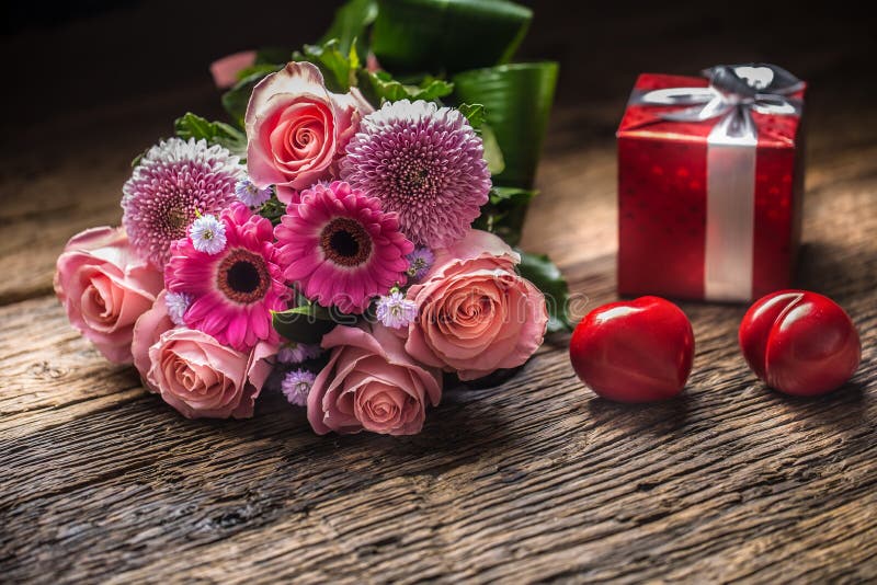 Ramo hermoso de flores con el regalo y los corazones rojos en de madera imágenes de archivo libres de regalías Ramo hermoso de flores con el regalo y los corazones rojos en de madera imágenes de archivo libres de regalías