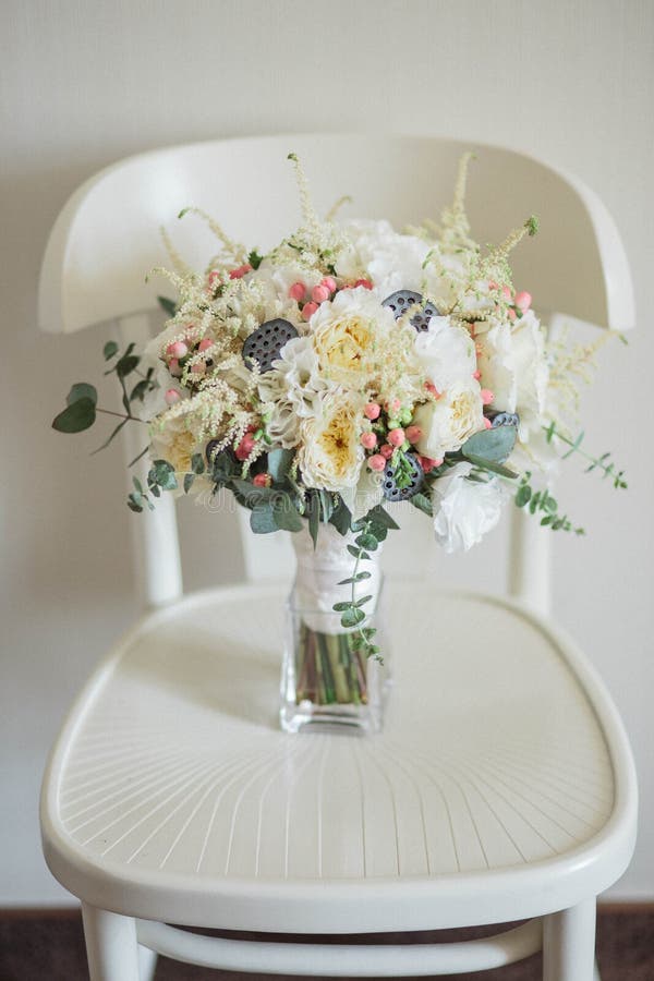 Ramo nupcial Hermoso de las flores blancas y del verdor, en silla de madera del vintage foto de archivo Ramo nupcial Hermoso de las flores blancas y del verdor, en silla de madera del vintage foto de archivo