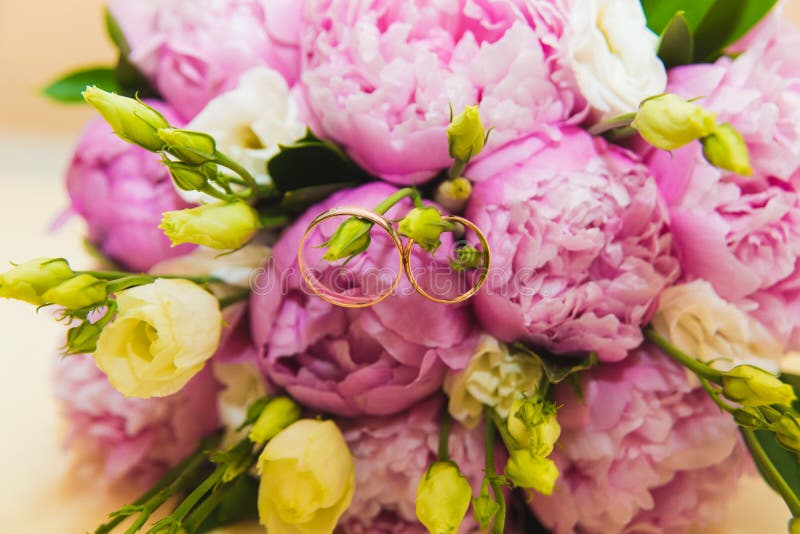 Ramo que se casa delicado hermoso de peonías y de anillos de bodas rosados de la novia y del novio imagen de archivo libre de regalías Ramo que se casa delicado hermoso de peonías y de anillos de bodas rosados de la novia y del novio imagen de archivo libre de regalías
