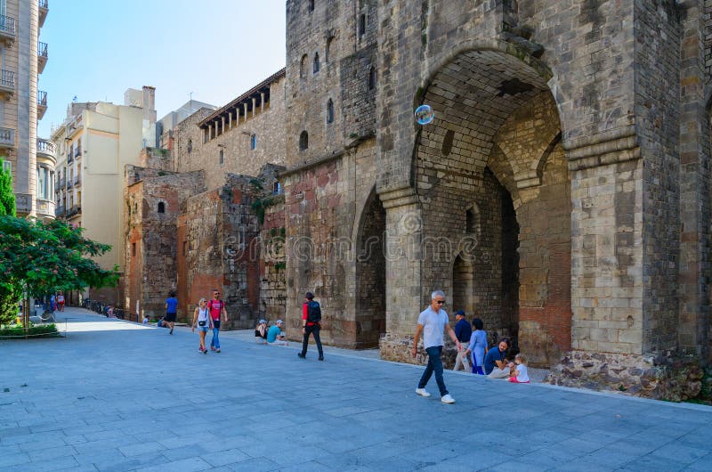 BARCELONA, SPAIN - SEPTEMBER 13, 2018: Unidentified people walk near ancient walls of Saint Agathaâ€™s chapel on Ramon Berenguer Square Placa de Ramon Berenguer el Gran in Gothic Quarter. BARCELONA, SPAIN - SEPTEMBER 13, 2018: Unidentified people walk near ancient walls of Saint Agathaâ€™s chapel on Ramon Berenguer Square Placa de Ramon Berenguer el Gran in Gothic Quarter