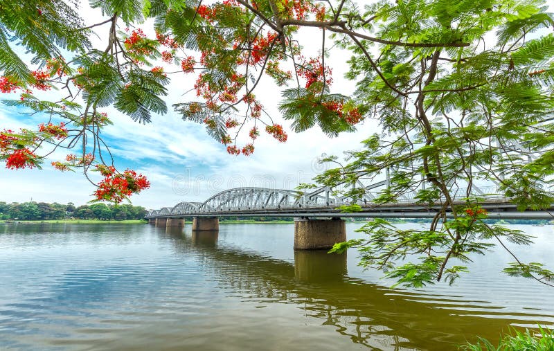 Ramos laterais chamativos de aparecimento de Trang Tien Bridge que refletem no rio
