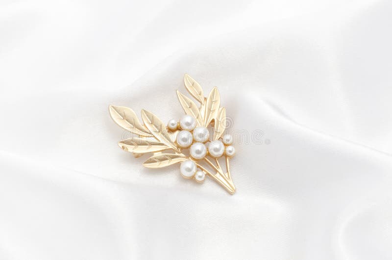 Ramoscello d'oro con perle su tessuto di seta.