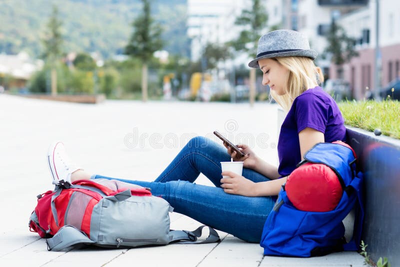 Randonneur féminin blond de repos avec le téléphone portable photo libre de droits Randonneur féminin blond de repos avec le téléphone portable photo libre de droits