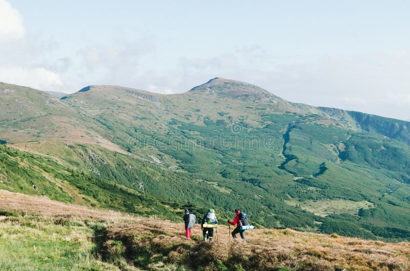 Randonneurs avec des sacs à dos la montagne et en appréciant la vue de la vallée. Randonneurs avec des sacs à dos détendant sur une montagne et appréciant la vue de la vallée