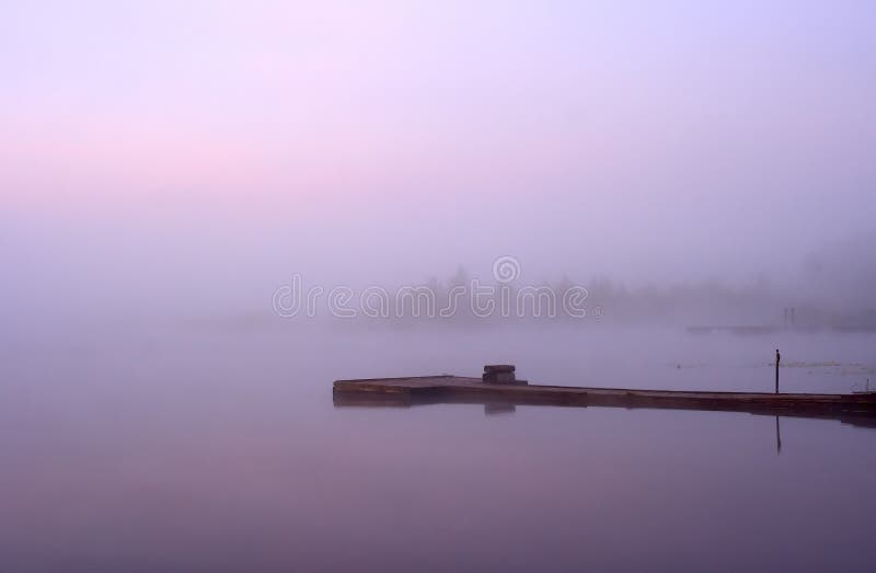 Morning nature scene (landscape): fog (mist) reflected in the water surface along with pink and blue sky, trees and moorage (quay, berth, wharf). The Seliger lake (Russia). Can be used as a background (backdrop) or wallpaper. Morning nature scene (landscape): fog (mist) reflected in the water surface along with pink and blue sky, trees and moorage (quay, berth, wharf). The Seliger lake (Russia). Can be used as a background (backdrop) or wallpaper.