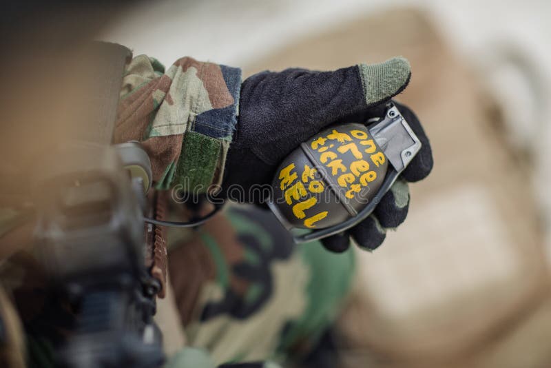 Soldier holding a green combat pineapple grenade. Soldier holding a green combat pineapple grenade