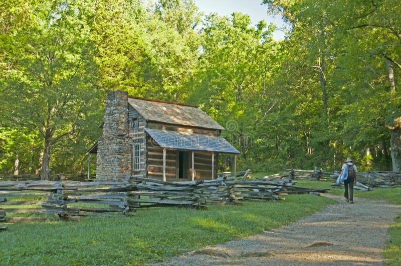 Ranger walking to an old log cabin.