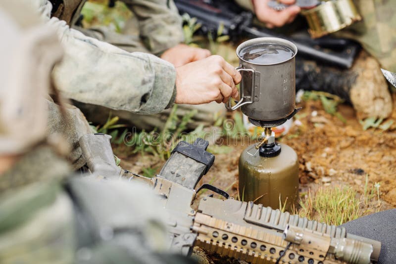 Rangers are Heated Food on the Fire and Eat in the Forest Stock Photo