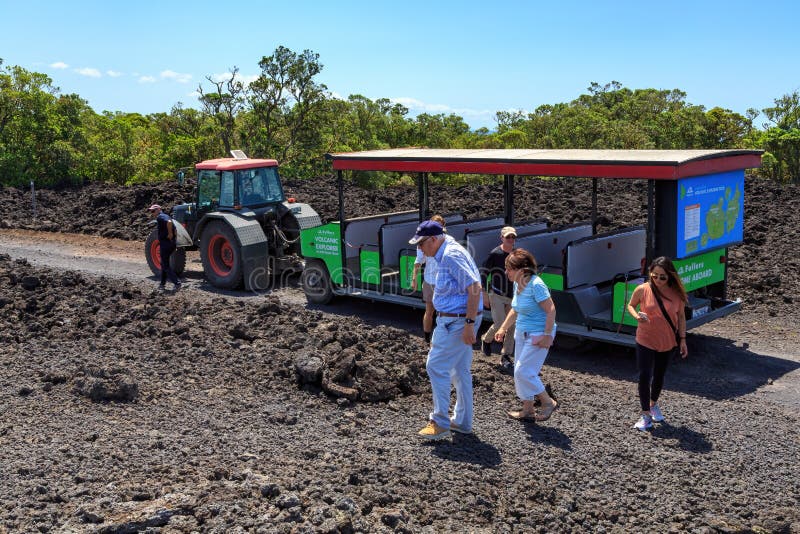 Tourists exploring Rangitoto Island, New Zealand, by `road train`. Rangitoto Island is a dormant volcano in the Hauraki Gulf near Auckland, New Zealand, with royalty free stock photo Tourists exploring Rangitoto Island, New Zealand, by `road train`. Rangitoto Island is a dormant volcano in the Hauraki Gulf near Auckland, New Zealand, with royalty free stock photo