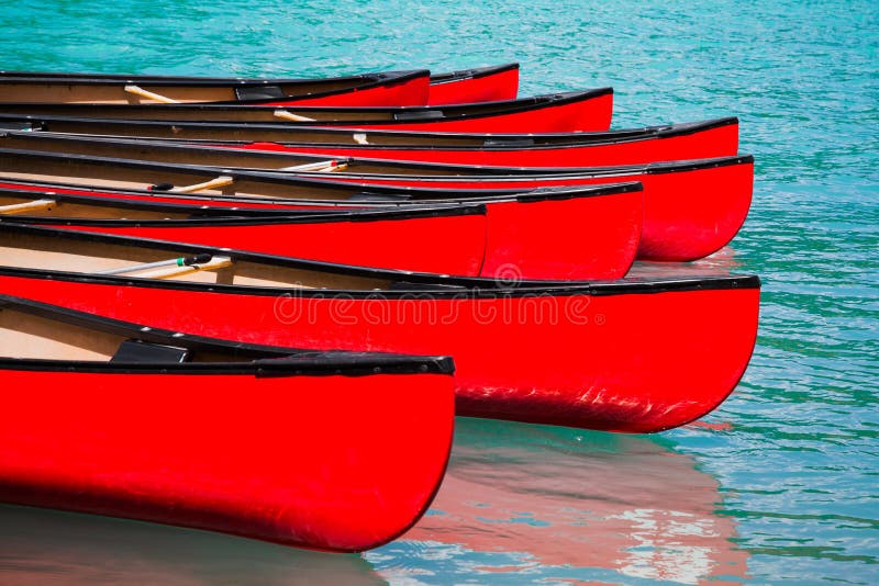 Rangée des canoës rouges dans le lac photos stock Rangée des canoës rouges dans le lac photos stock