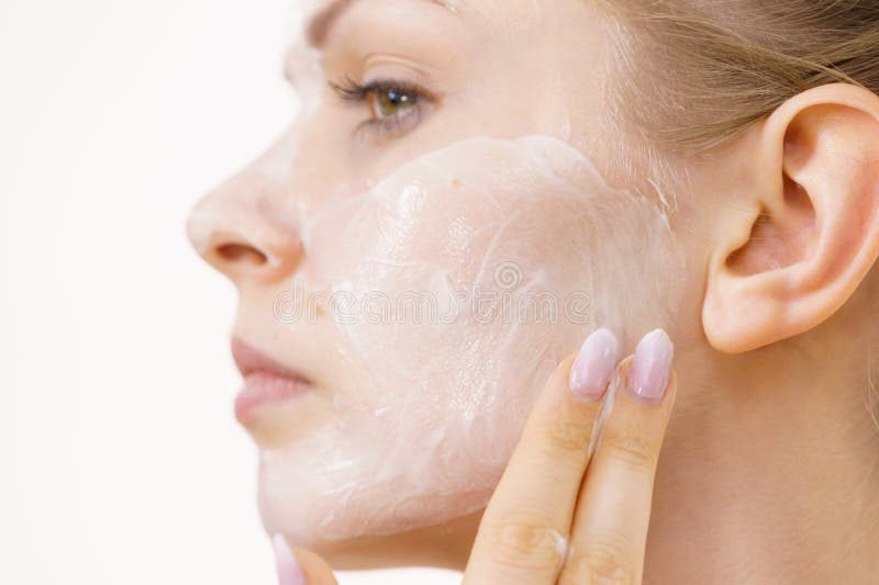Rapariga aplica creme cosmético imagens de stock royalty free