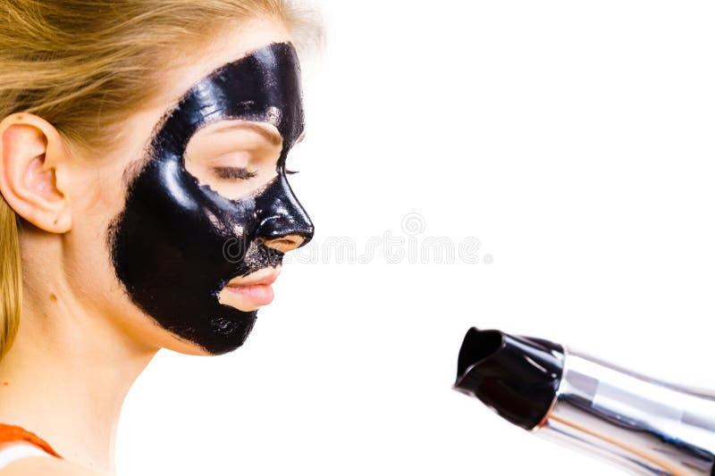 Rapariga a secar máscara preta descascável no rosto fotos de stock royalty free