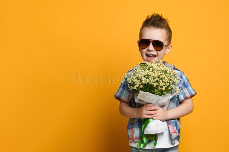 Rapaz pequeno bonito que guarda um ramalhete das flores fotografia de stock Rapaz pequeno bonito que guarda um ramalhete das flores fotografia de stock