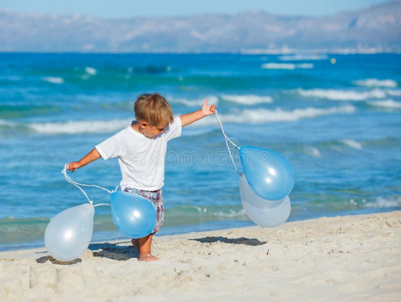 Rapaz pequeno com ballons na praia foto de stock royalty free Rapaz pequeno com ballons na praia foto de stock royalty free