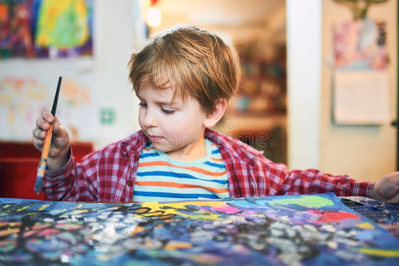 Cute happy little boy, adorable preschooler, painting in a sunny art studio. Young artist at work. Cute happy little boy, adorable preschooler, painting in a sunny art studio. Young artist at work.