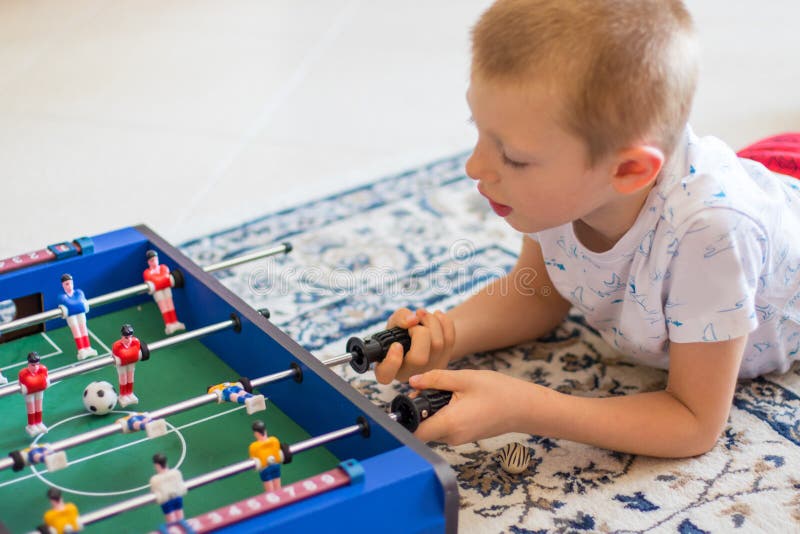 Rapaz pequeno que joga com foosball imagens de stock Rapaz pequeno que joga com foosball imagens de stock
