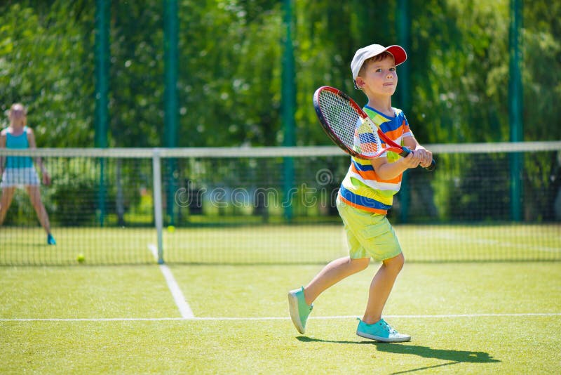 Rapaz pequeno que joga o tênis