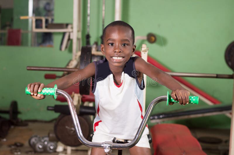 Smiling little boy trains on a bike to acquire fitness. Smiling little boy trains on a bike to acquire fitness.