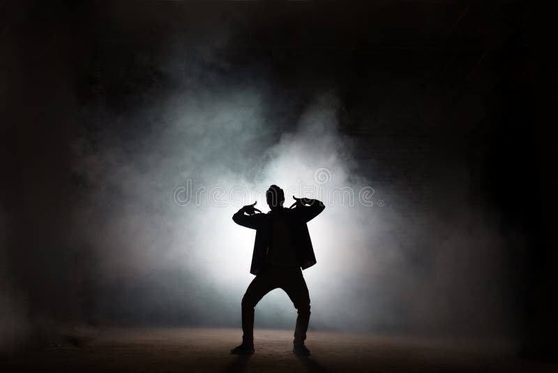 Young rapper dancing isolated on black background. Young rapper dancing isolated on black background