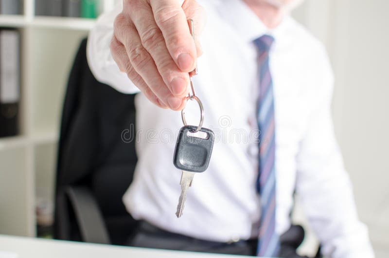 Venditore di auto che tiene una chiave immagini stock