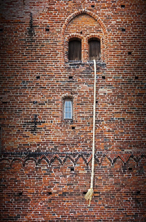 Rapunzel story, a long blond hair plait hanging out of the window of an old brick tower
