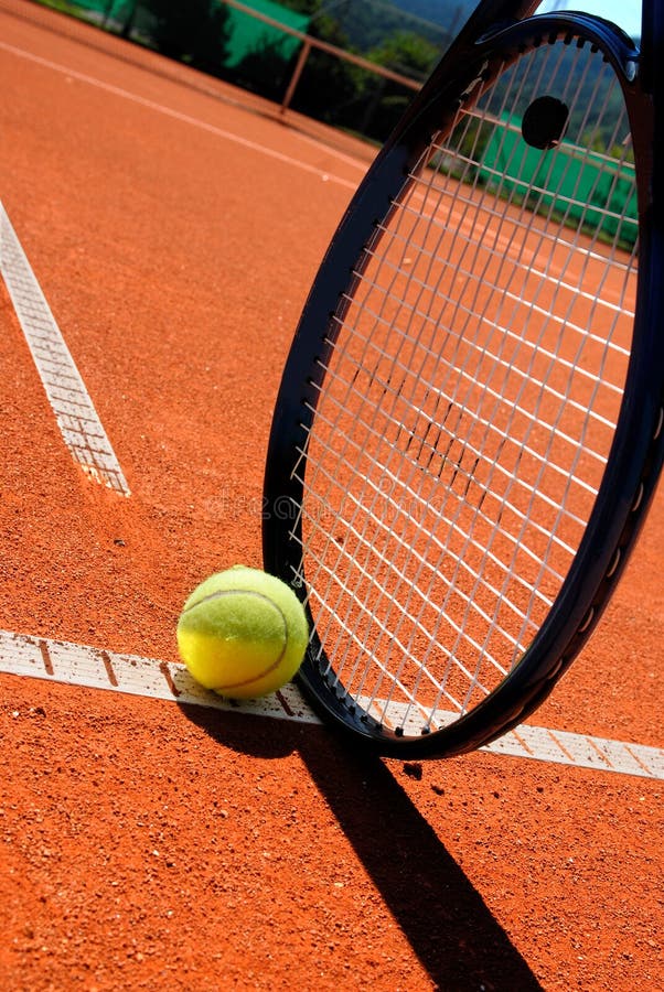 Raqueta y bola de tenis en el campo de tenis fotografía de archivo libre de regalías Raqueta y bola de tenis en el campo de tenis fotografía de archivo libre de regalías